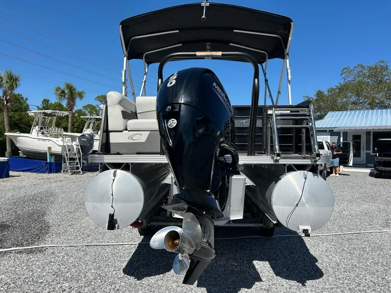 Slide: The Image of 2021 Crest 240 LX SLSC pontoon boat with outboard motor, parked on gravel. - 3