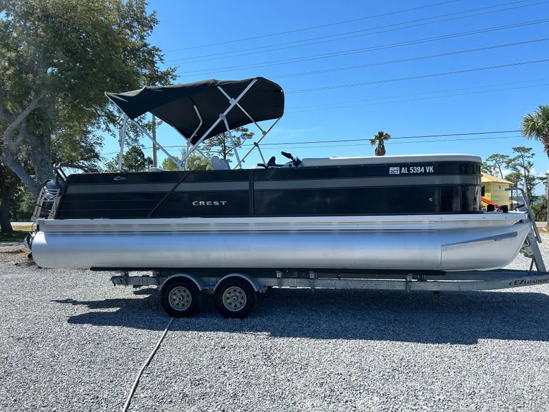 Slide: The Image of 2021 Crest 240 LX SLSC pontoon boat on trailer, parked outdoors under clear sky. - 5