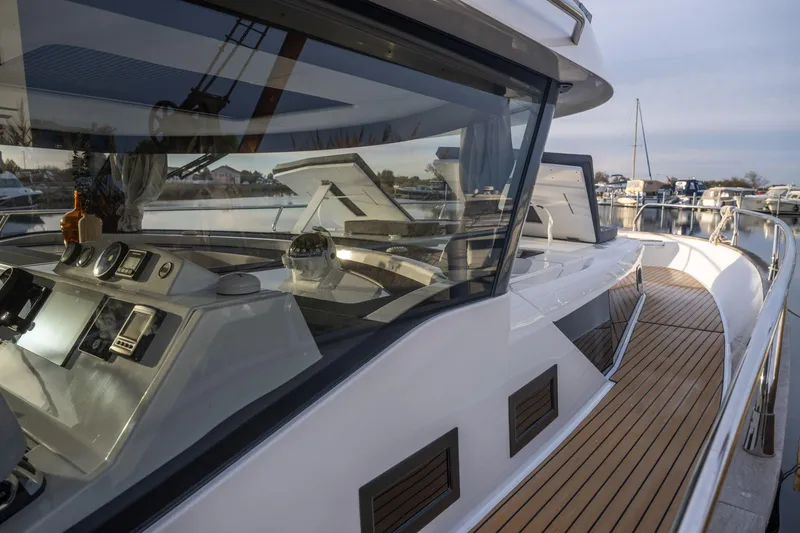 Slide: The Image of 2025 Delphia D12 Fly yacht with sleek design and modern cockpit, docked at marina. - 5