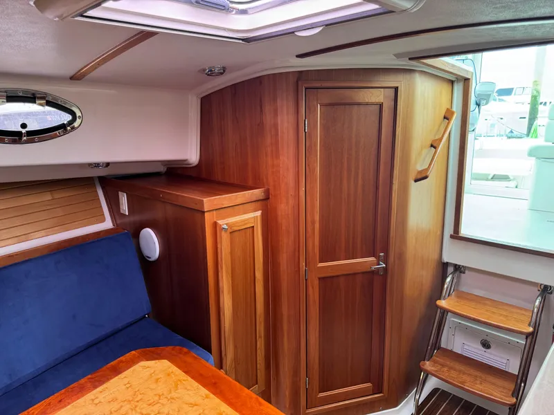 Slide: The Image of 2008 Back Cove 29 Hardback boat interior with helm, seating, and windows overlooking marina. - 16