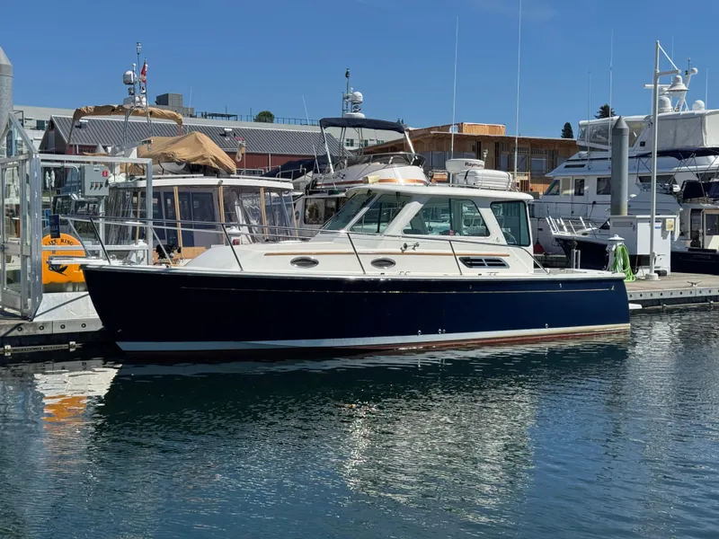 Slide: The Image of 2008 Back Cove 29 Hardback boat docked at marina, blue hull, clear sky background. - 2