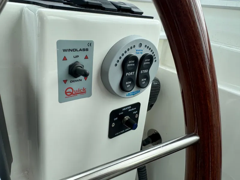 Slide: The Image of Electrical control panel of a 2008 Back Cove 29 Hardback boat, featuring switches and stereo system. - 24