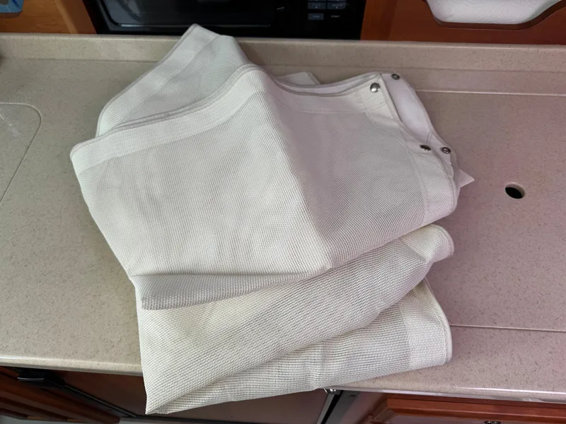 Slide: The Image of Folded white fabric with grommets on a countertop, possibly for a 2008 Back Cove 29 Hardback. - 49