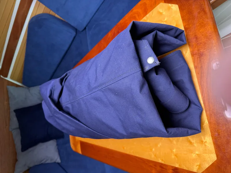 Slide: The Image of Folded navy fabric on wooden table inside 2008 Back Cove 29 Hardback boat. - 50