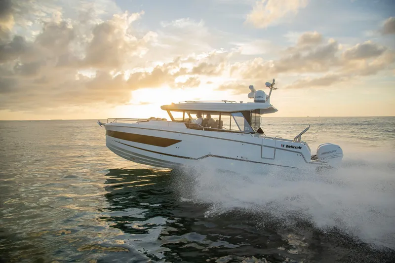 Slide: The Image of 2025 Wellcraft 38 Explorer boat cruising at sunset on the ocean. - 1