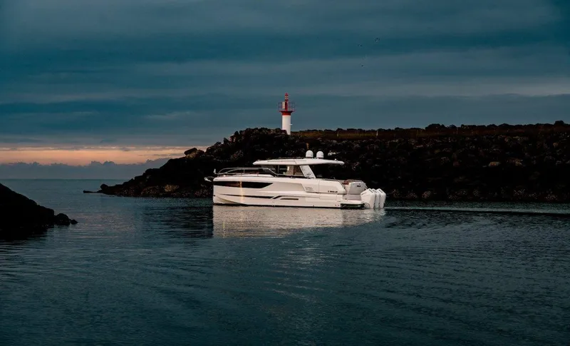 Slide: The Image of 2025 Wellcraft 44 Explorer yacht near a lighthouse at dusk. - 5