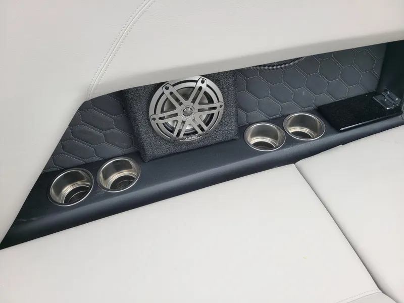 Slide: The Image of 2023 Four Winns H4 boat interior with speaker, cup holders, and quilted upholstery. - 14