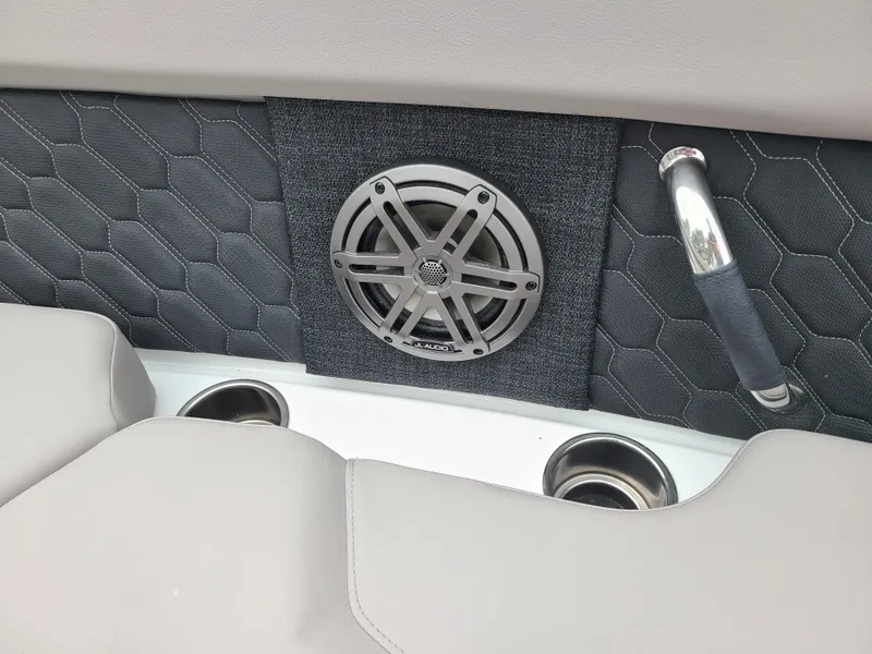 Slide: The Image of 2023 Four Winns H4 boat interior with speaker, cup holders, and textured upholstery. - 16