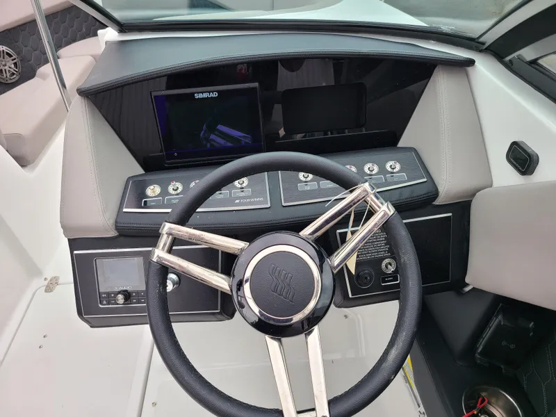 Slide: The Image of 2023 Four Winns H4 boat dashboard with steering wheel and control panel. - 18
