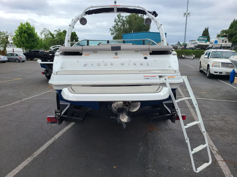 Slide: The Image of 2023 Four Winns H4 boat, rear view with ladder, parked in a lot. - 8