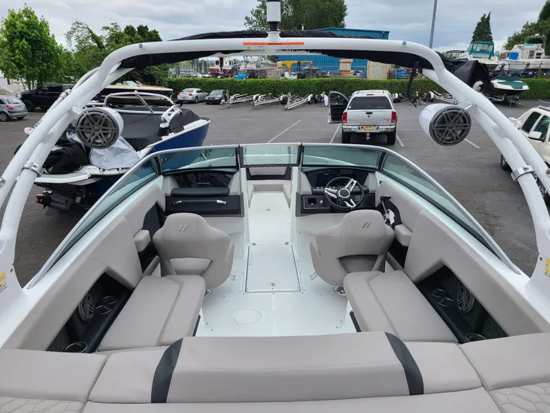 Slide: The Image of 2023 Four Winns H4 boat interior with sleek seating and modern design in a parking lot. - 9