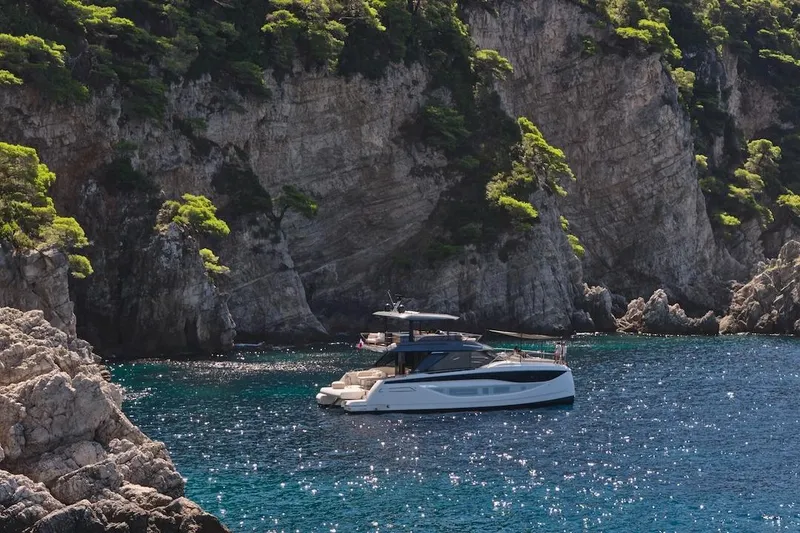 Slide: The Image of Luxury Prestige M7 yacht cruising near rocky cliffs, 2025 model. - 103