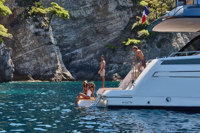Slide: The Image of Luxury Prestige M7 yacht near rocky coastline, people enjoying the sun, 2025 model. - 108