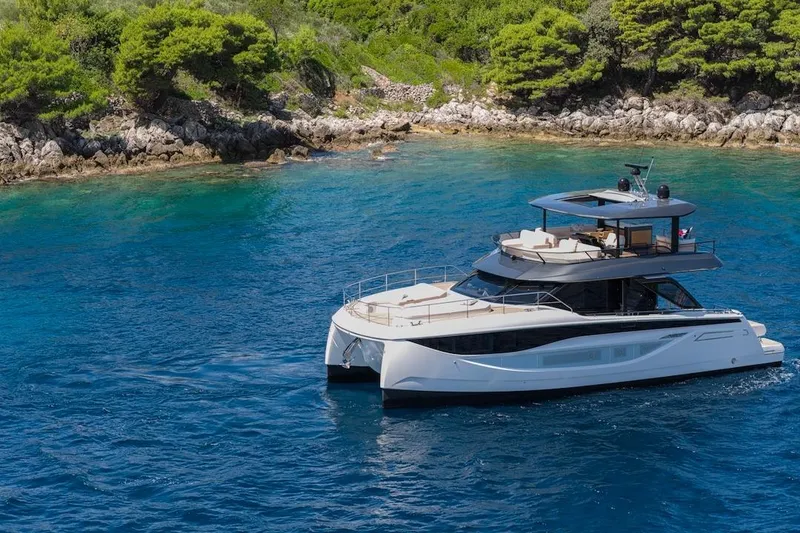 Slide: The Image of Luxurious 2025 Prestige M7 yacht cruising near a scenic, rocky coastline. - 48