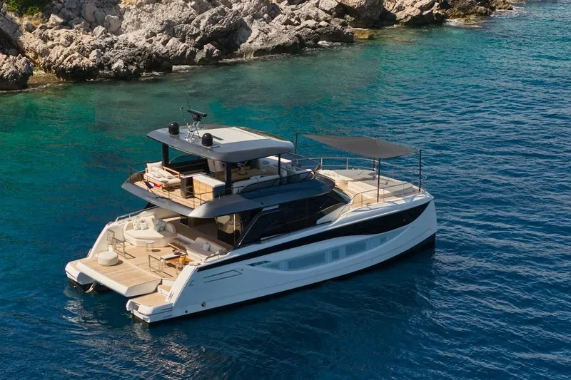 Slide: The Image of Luxurious 2025 Prestige M7 yacht cruising in clear blue waters near rocky shoreline. - 56