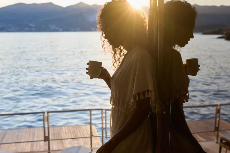 Slide: The Image of Woman enjoying sunset on Prestige M7 yacht, 2025 model, holding a cup by the sea. - 70