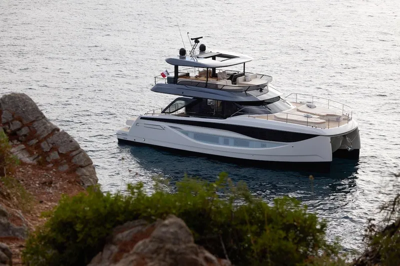 Slide: The Image of Luxurious 2025 Prestige M7 yacht cruising on serene waters near rocky shoreline. - 92