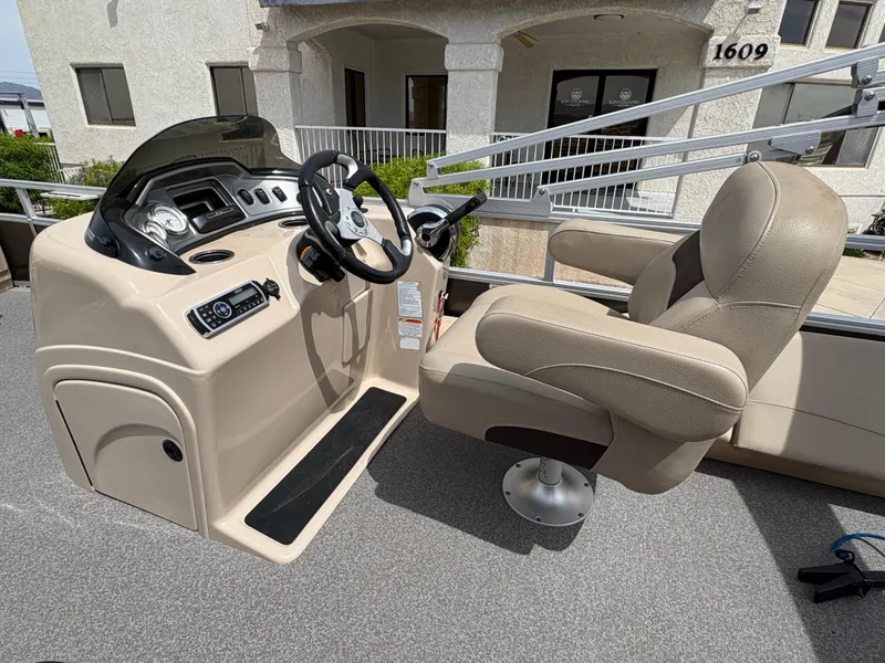 Slide: The Image of 2017 Sun Tracker Fishin' Barge 22 DLX helm with beige captain's chair and control panel. - 11