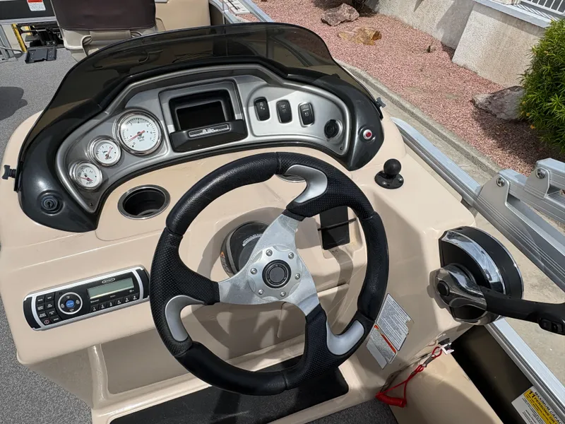 Slide: The Image of 2017 Sun Tracker Fishin' Barge 22 DLX dashboard with steering wheel and control panel. - 12