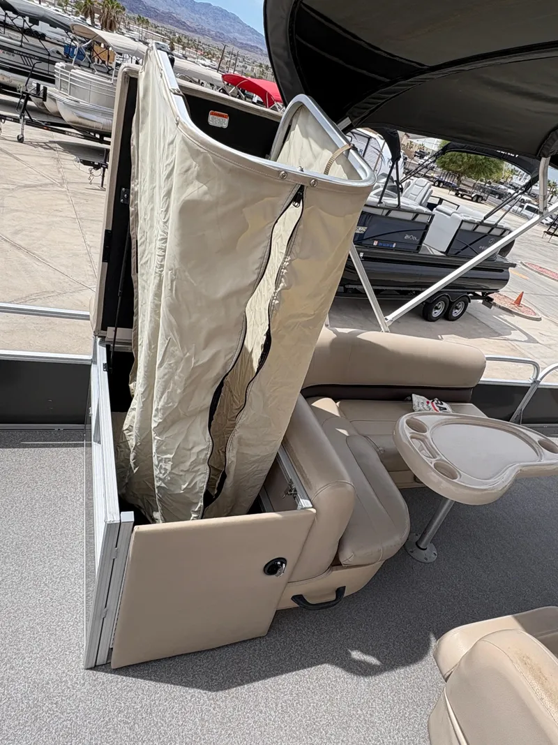 Slide: The Image of 2017 Sun Tracker Fishin' Barge 22 DLX with beige seating and privacy curtain on deck. - 13