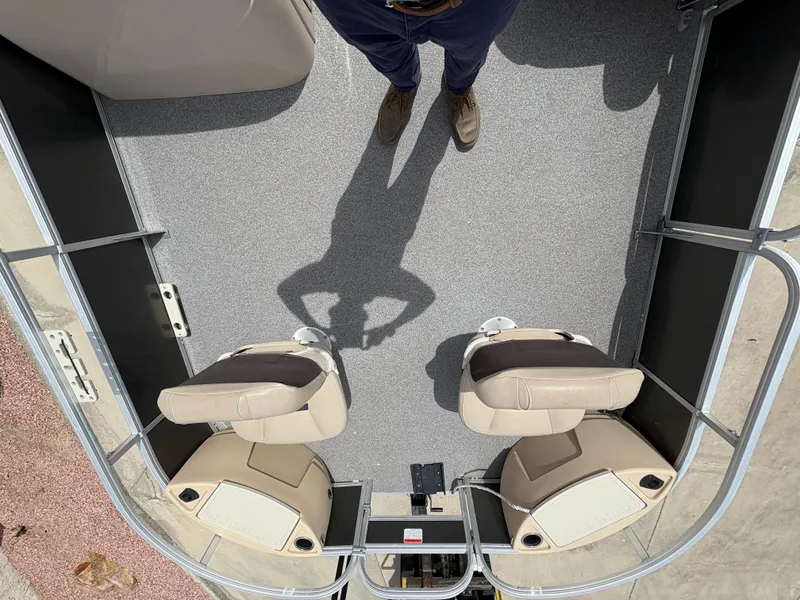 Slide: The Image of 2017 Sun Tracker Fishin' Barge 22 DLX interior with two beige seats and gray flooring. - 8