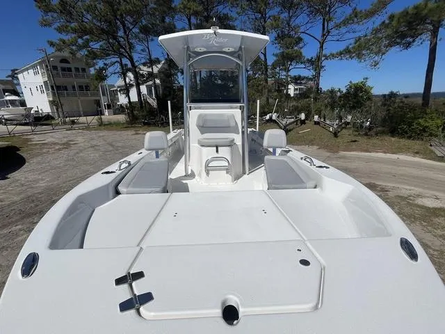 Slide: The Image of 2025 Bay Rider 239 Bay boat with spacious deck and seating, set against a coastal backdrop. - 7