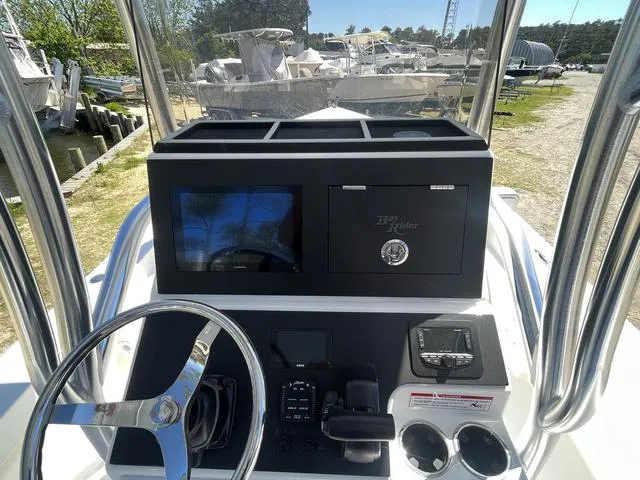 Slide: The Image of Bay Rider 239 Bay 2025 boat console with steering wheel and navigation equipment. - 9