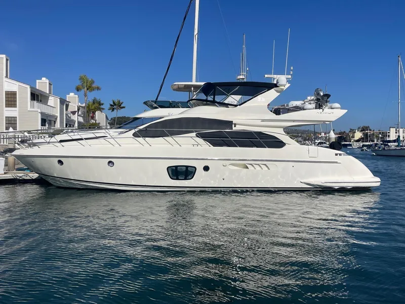 Slide: The Image of 2006 Azimut 55E yacht docked in a marina under clear blue skies. - 0