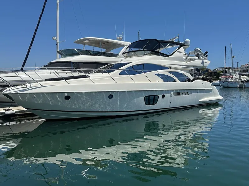 Slide: The Image of 2006 Azimut 55E yacht docked in a marina under clear blue skies. - 1