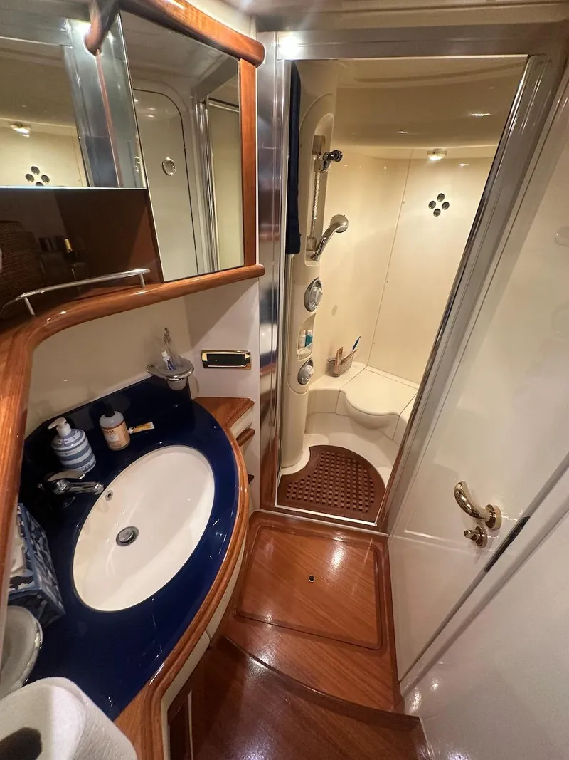 Slide: The Image of Luxurious bathroom in a 2006 Azimut 55E yacht with modern fixtures and elegant wood accents. - 15