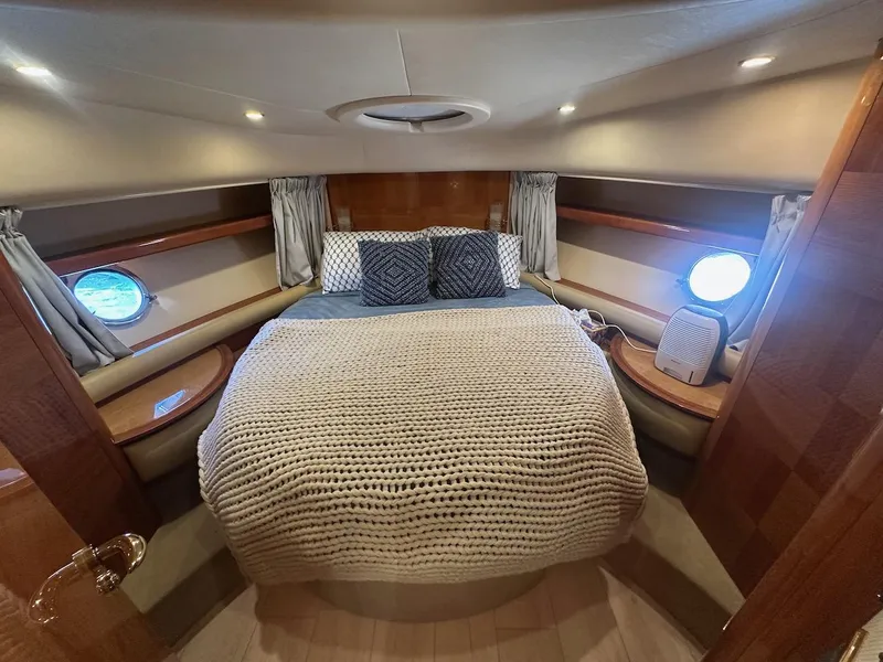 Slide: The Image of Luxurious bedroom interior of a 2006 Azimut 55E yacht with cozy bedding and porthole windows. - 17