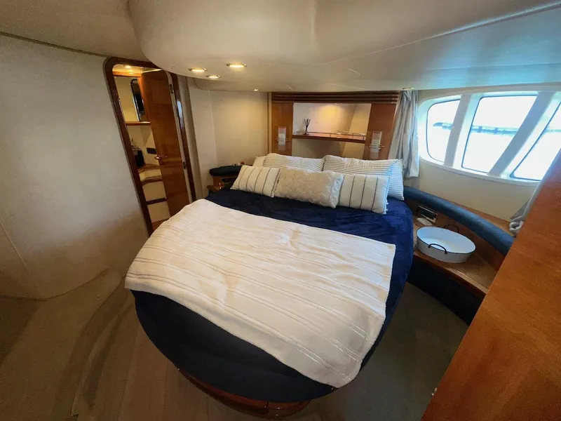 Slide: The Image of Luxurious bedroom interior of a 2006 Azimut 55E yacht with elegant bedding and large windows. - 23