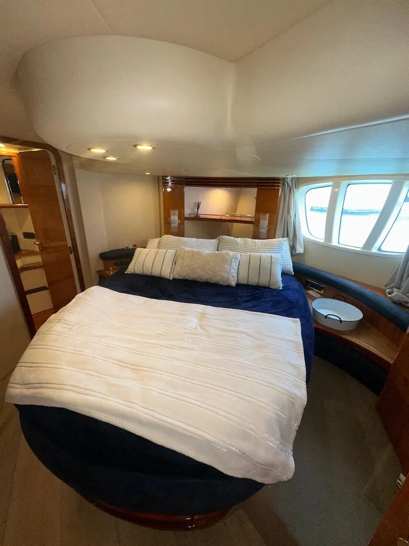 Slide: The Image of Luxurious bedroom interior of 2006 Azimut 55E yacht with elegant bedding and large windows. - 24