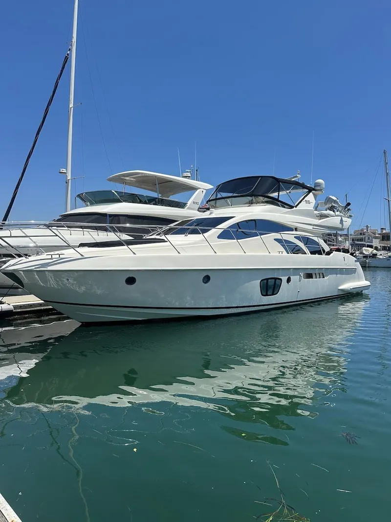 Slide: The Image of 2006 Azimut 55E yacht docked in a marina under clear blue skies. - 47
