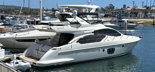 Slide: The Image of 2006 Azimut 55E yacht docked in a marina, showcasing sleek design and luxury features. - 49