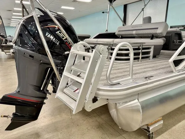 Slide: The Image of 2025 Bennington M Swingback 22 MSB pontoon boat with Yamaha engine, displayed indoors. - 13