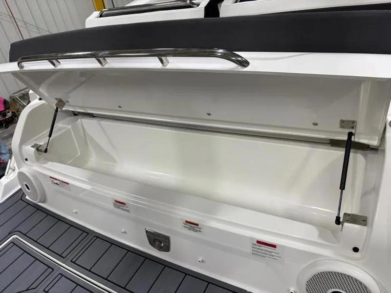 Slide: The Image of Open storage compartment on 2025 Cobalt R31 boat, featuring hydraulic supports and sleek design. - 27
