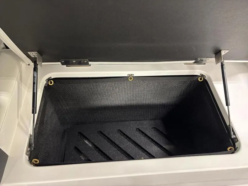 Slide: The Image of Open storage compartment in 2025 Cobalt R31 boat, featuring durable black interior. - 33