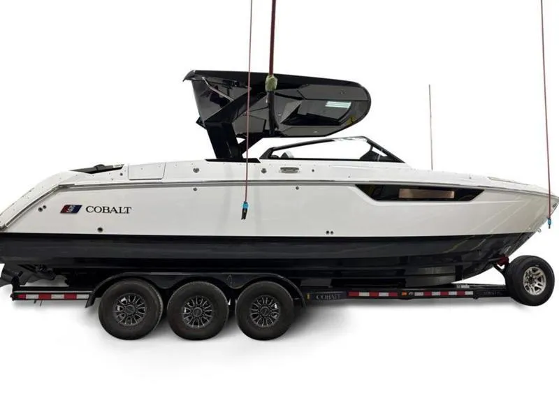 Slide: The Image of 2025 Cobalt R31 boat on trailer, sleek design, black and white color scheme. - 4
