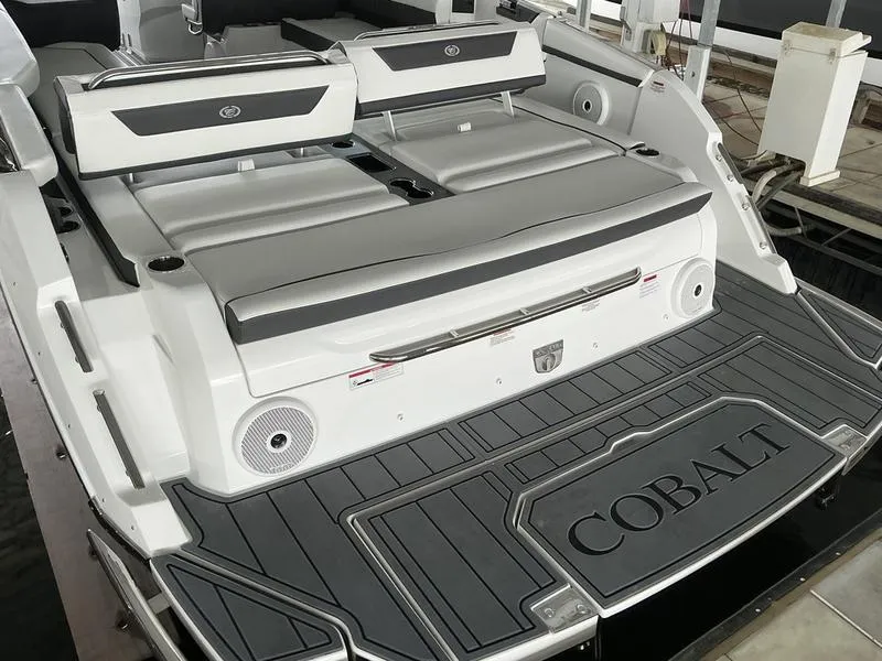 Slide: The Image of 2025 Cobalt R31 boat with sleek seating and deck design in a marina setting. - 44
