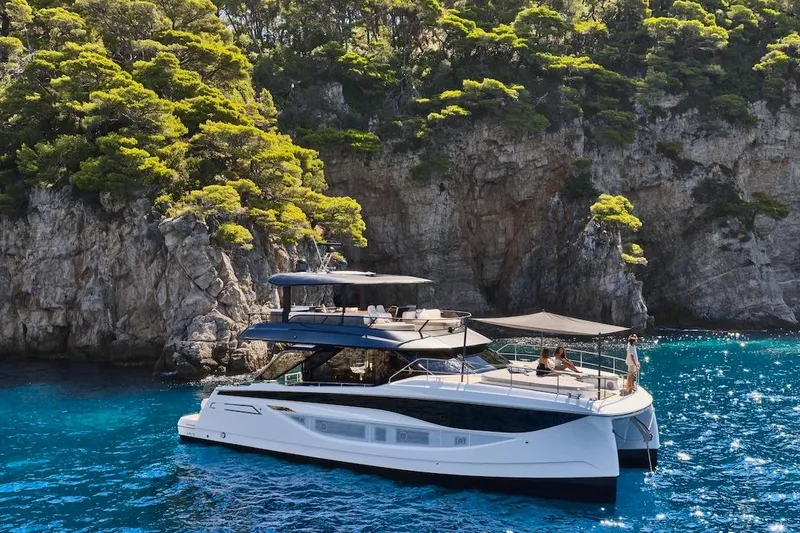 Slide: The Image of Luxurious 2025 Prestige M7 yacht cruising near rocky coastline with lush greenery. - 100