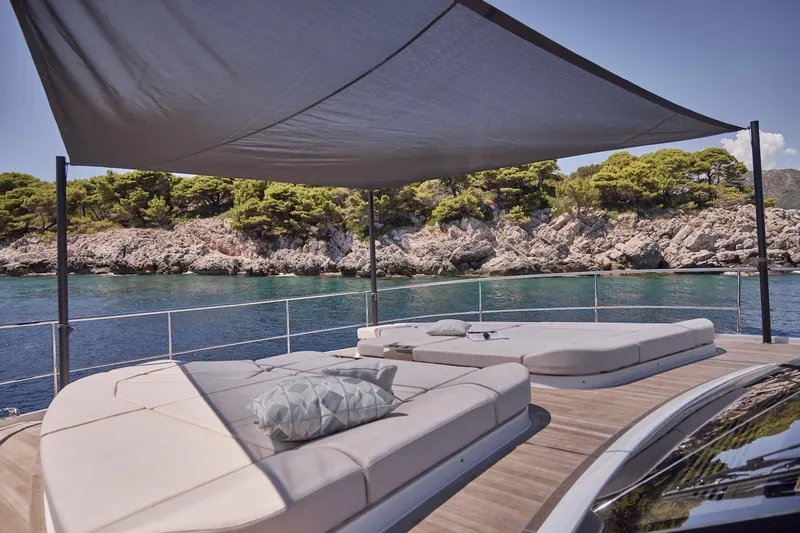 Slide: The Image of Luxurious Prestige M7 yacht deck with sunbeds, canopy, and scenic coastal view, 2025 model. - 51