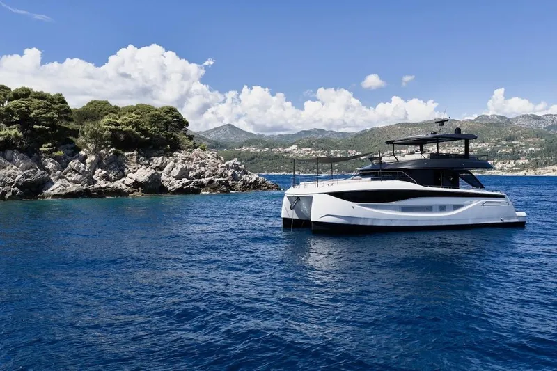 Slide: The Image of Luxury Prestige M7 yacht cruising near rocky coastline, 2025 model. - 52