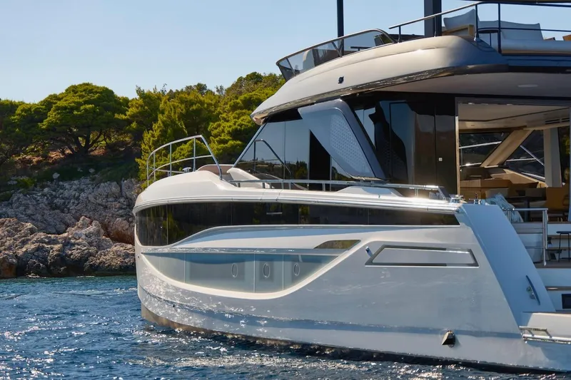 Slide: The Image of Luxury 2025 Prestige M7 yacht cruising near rocky shoreline and lush greenery. - 61