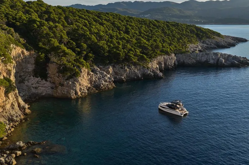 Slide: The Image of Luxury Prestige M7 yacht cruising near scenic rocky coastline, 2025 model. - 69