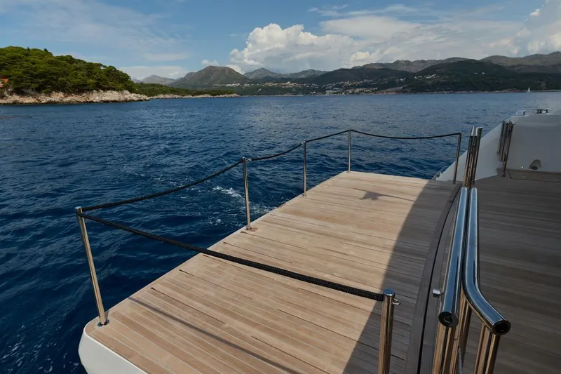 Slide: The Image of Prestige M7 yacht deck overlooking scenic coastal waters, 2025 model. - 80