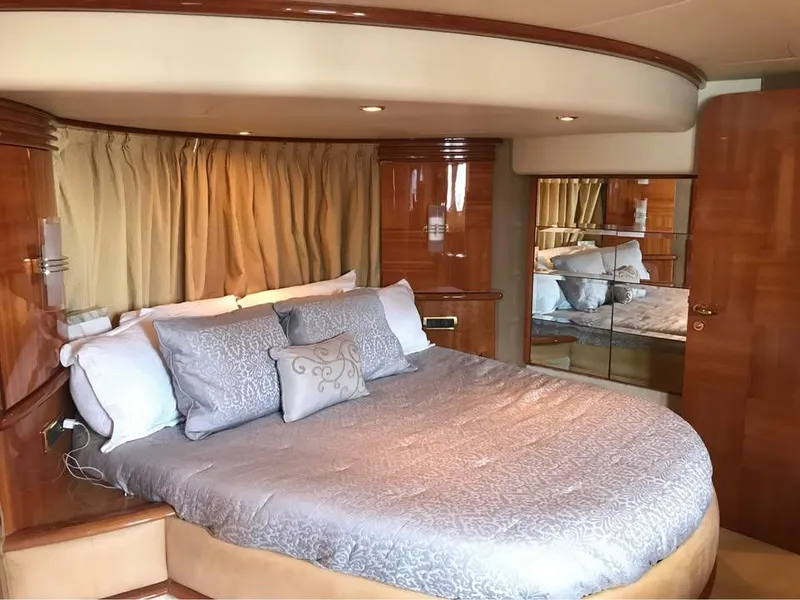 Slide: The Image of Luxurious bedroom interior of a 2006 Azimut 62 yacht with elegant bedding and wood finishes. - 11