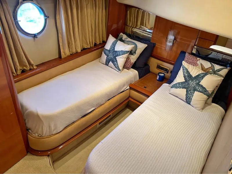 Slide: The Image of Twin cabin in 2006 Azimut 62 yacht with starfish-themed pillows and porthole window. - 15