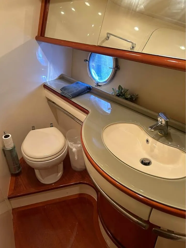 Slide: The Image of 2006 Azimut 62 yacht bathroom with sink, toilet, and porthole window. - 17