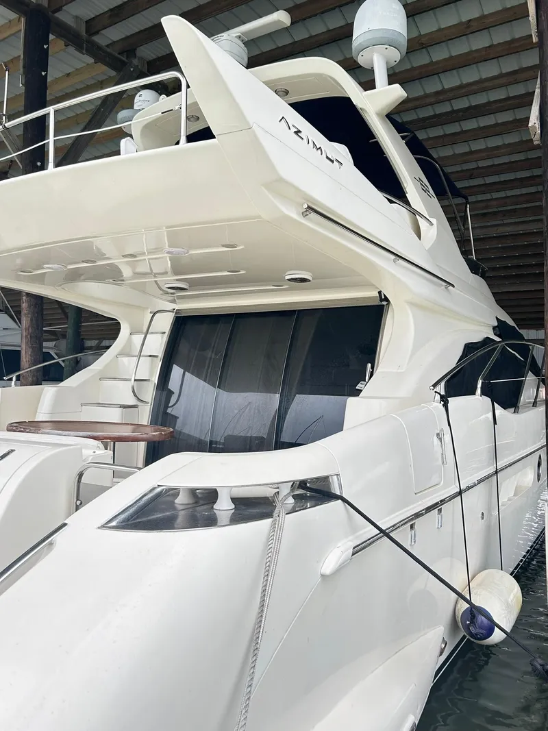 Slide: The Image of 2006 Azimut 62 yacht docked in a marina, showcasing sleek design and luxury features. - 18